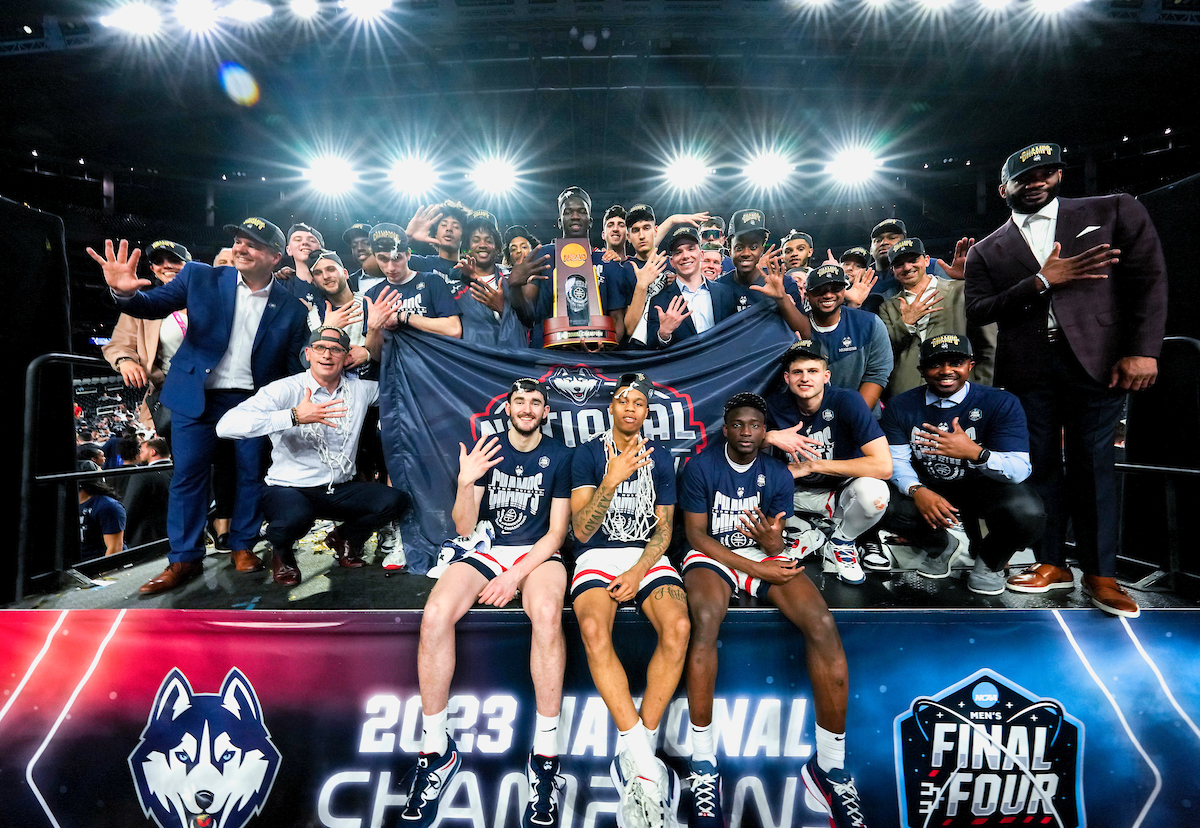 UConn Men's Basketball team with the 2023 national championship trophy